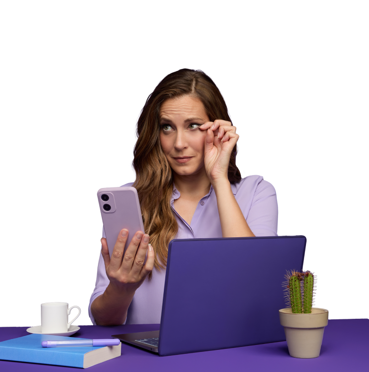 Woman in purple holding a phone rubbing her eye 