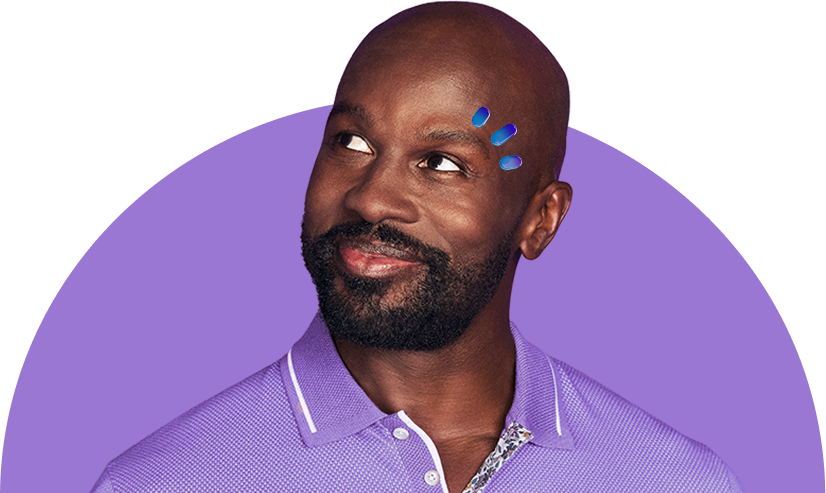 A man in a purple shirt smiling with three drops above his eye